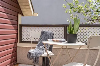 a table and chairs on a patio with a potted plant at Mid Century Zen Suite. 1 BR. Near DT, C-train. in Calgary