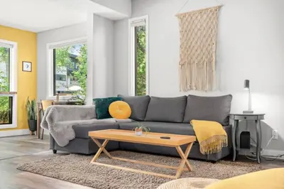 a living room with a gray couch and a coffee table at Funky 1 BR Century Home-Near DT, C-train in Calgary