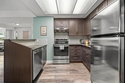 a kitchen with wooden cabinets and stainless steel appliances at Funky 1 BR Century Home-Near DT, C-train in Calgary