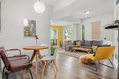 a living room with a couch and a table and chairs at Funky 1 BR Century Home-Near DT, C-train in Calgary