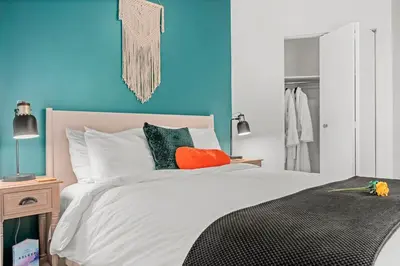 a bedroom with a white bed and a blue wall at Funky 1 BR Century Home-Near DT, C-train in Calgary