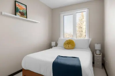 a bedroom with a white bed with a pumpkin on it at Bright and Welcoming Mount Pleasant Home, near DT in Calgary