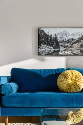 a blue couch in a living room with a picture on the wall at Bright and Welcoming Mount Pleasant Home, near DT in Calgary