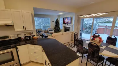 a kitchen and living room with a table and chairs at Premium stay in Metro Vancouver-World Cup ready in Coquitlam