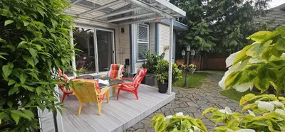 a patio with colorful chairs and a table on a porch at Premium stay in Metro Vancouver-World Cup ready in Coquitlam