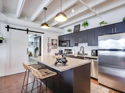 a kitchen with a large island with bar stools at Luxury 2BR 2BA Loft Ice District W Heated Parking in Edmonton