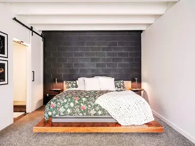 a bedroom with a bed with a black wall at Luxury 2BR 2BA Loft Ice District W Heated Parking in Edmonton