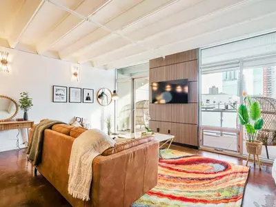 a living room with a couch and a tv at Luxury 2BR 2BA Loft Ice District W Heated Parking in Edmonton