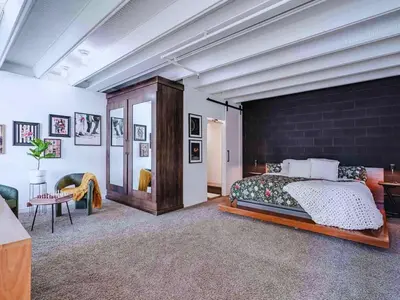 a bedroom with a large bed and a brick wall at Luxury 2BR 2BA Loft Ice District W Heated Parking in Edmonton