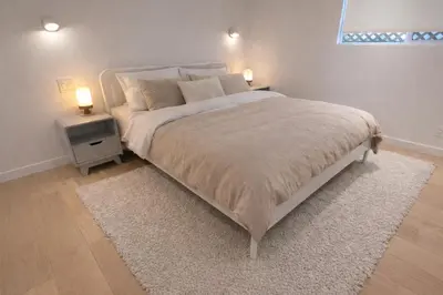 a bedroom with a bed with a white bedspread and two lamps at Modern 3-Bdrm Home & Parking - Cambie Village-VGH in Vancouver