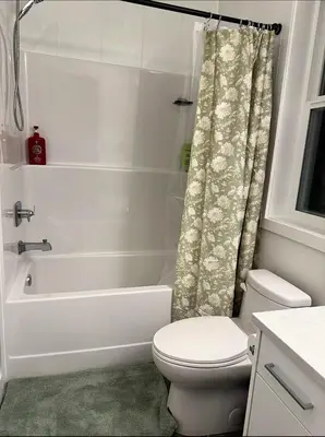 a white bathroom with a toilet and a bath tub at Luxury 2-Bedroom Suite at Bear Mountain Victoria in Langford