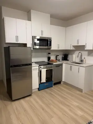 a kitchen with stainless steel appliances and white cabinets at Luxury 2-Bedroom Suite at Bear Mountain Victoria in Langford