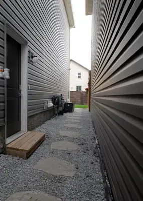 a walkway next to a building with a fence at Cozy Luxe 1BR Suite in Calgary