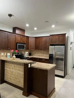 a kitchen with wooden cabinets and a stainless steel refrigerator at 2 Bedroom plus den 2 Bathroom apartment in Surrey