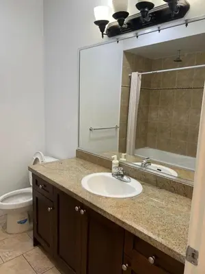 a bathroom with a sink and a toilet and a mirror at 2 Bedroom plus den 2 Bathroom apartment in Surrey