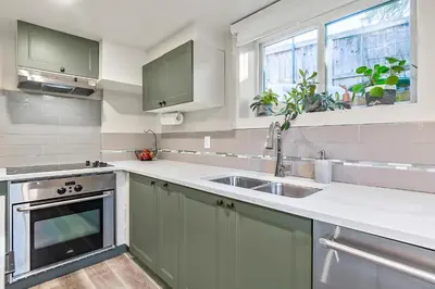 a kitchen with green cabinets and a sink at Bright & Cozy Central Retreat in Calgary