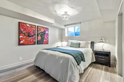 a bedroom with a bed and a painting on the wall at Bright & Cozy Central Retreat in Calgary