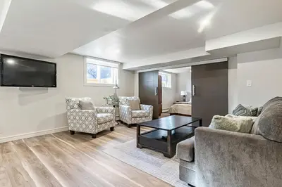 a living room with a couch and chairs and a tv at Bright & Cozy Central Retreat in Calgary