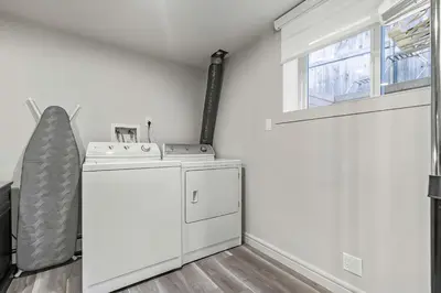 a washing machine in a room with a window at Bright & Cozy Central Retreat in Calgary
