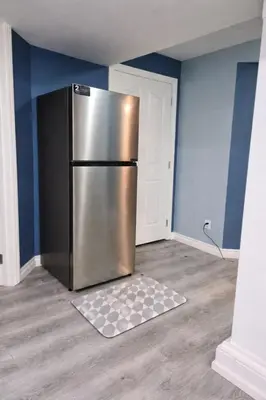 a kitchen with a stainless steel refrigerator in a room at Home Basement, Friendly Family in Calgary