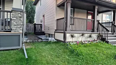 a house with a balcony and a yard with flowers at Home Basement, Friendly Family in Calgary