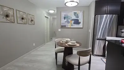 a kitchen with a table and chairs in a room at SkyHaven Urban Condo near YYC Airport in Calgary
