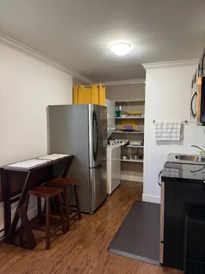 a kitchen with a stainless steel refrigerator and a table at Private 1BR, AC, Strong Wi-Fi, Netflix and Amazon Prime in Victoria