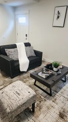 a living room with a couch and a coffee table at Hebzibah's Luxe in Prince George