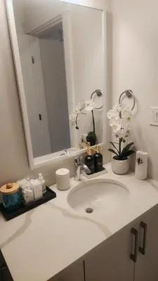 a bathroom with a white sink and a mirror at Hebzibah's Luxe in Prince George