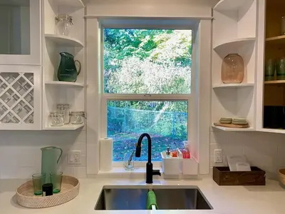 a kitchen with a sink and a window at Retreat to Quail Cottage in Chemainus