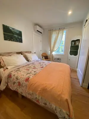 a bedroom with a large bed and a window at Retreat to Quail Cottage in Chemainus