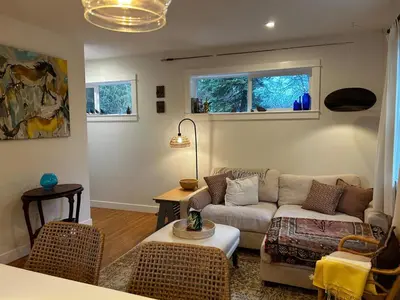 a living room with a couch and a table at Retreat to Quail Cottage in Chemainus