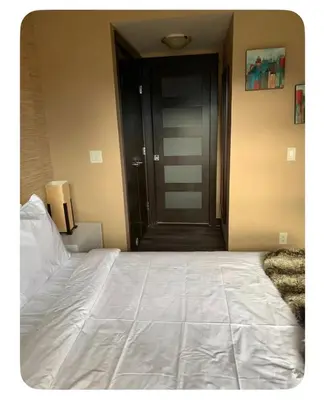 a bedroom with a large white bed and a black door at Canmore Mountain View in Canmore
