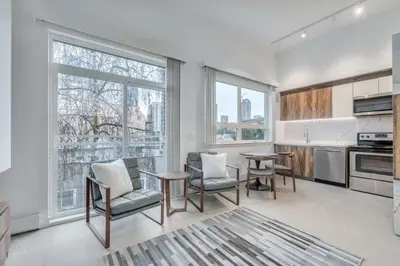 a kitchen with a table and chairs and windows at Modern Studio Condo in Central Prime Location in Vancouver