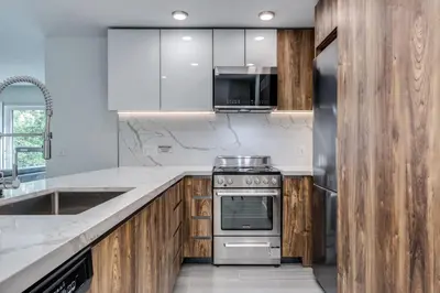 a kitchen with wooden cabinets and a stainless steel oven at Luxury 2BR Walk to Everything Downtown in Vancouver