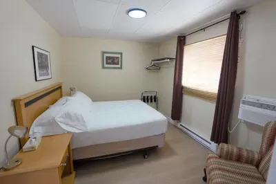 a bedroom with a bed and a desk and a chair at Park Motel in Hope