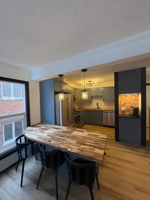 a kitchen and dining room with a table and chairs at Charming Mission Downtown Condo in Calgary