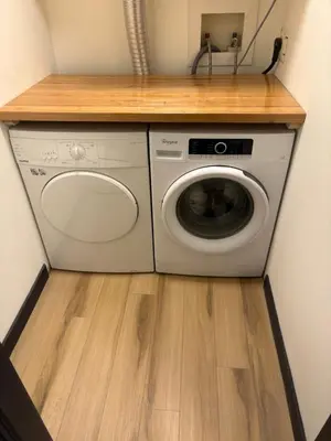 a washer and dryer in a kitchen with a wooden counter at Charming Mission Downtown Condo in Calgary