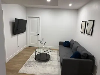 a living room with a couch and a tv at Cozy 1 Bedroom suite close to west edmonton mall in Edmonton