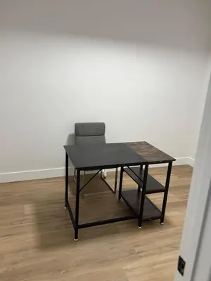 a black table and a chair in a room at Cozy 1 Bedroom suite close to west edmonton mall in Edmonton