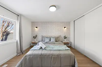 a bedroom with a large bed and a window at Affordable & Cozy 3-bedroom, Minutes to City Core in Calgary