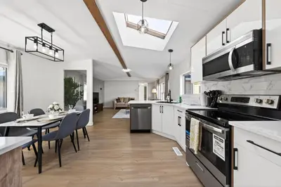 a kitchen with a table and a dining room at Affordable & Cozy 3-bedroom, Minutes to City Core in Calgary