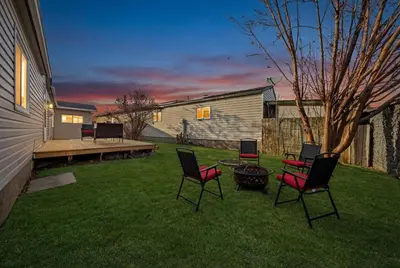 a yard with chairs and a table and a house at Affordable & Cozy 3-bedroom, Minutes to City Core in Calgary