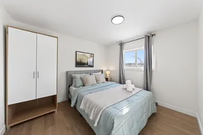 a bedroom with a bed and a window at Affordable & Cozy 3-bedroom, Minutes to City Core in Calgary