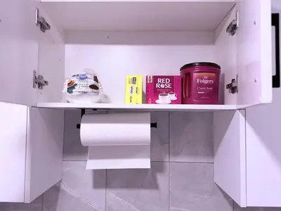 a shelf with toilet paper and books in a bathroom at Cozy Haven 2 in Bélanger