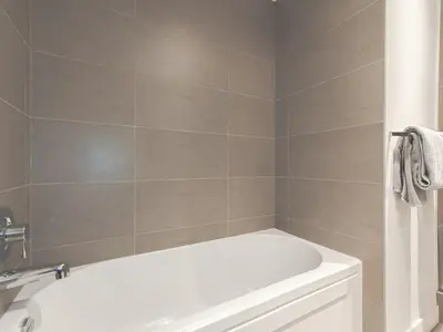 a bathroom with a white tub and a white sink at Gastown Unbeatable View 1 Bedroom High Floor Condo Rooftop View of Downtown in Vancouver