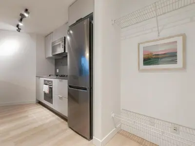 a kitchen with a stainless steel refrigerator at Gastown Unbeatable View 1 Bedroom High Floor Condo Rooftop View of Downtown in Vancouver