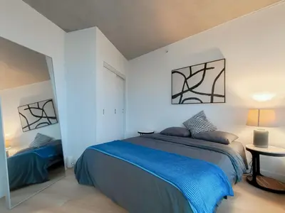 a bedroom with a blue bed and a table at Gastown Unbeatable View 1 Bedroom High Floor Condo Rooftop View of Downtown in Vancouver