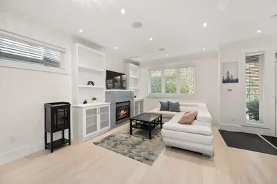 a white living room with a white couch and a fireplace at Your Next Stay Spacious Bright & Sophisticated in Vancouver