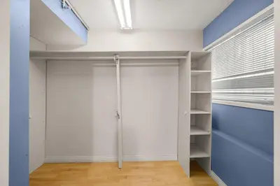 a walk in closet with white walls and blue doors at Ultimate FIFA House 5BR with Games in Vancouver